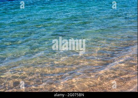 Abstrakter Meereshintergrund. Abstrakter Sandstrand im Sommer mit blauem Meer. Wunderschöne Textur. Speicherplatz kopieren Stockfoto