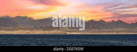 Sonnenuntergang im Sinai-Gebirge, Ägypten. Panorama des Sinai-Gebirges bei einem atemberaubenden Sonnenuntergang. Bunte Landschaft. Wunderbares solares rotes Meer. Bibellandschaft - Stockfoto