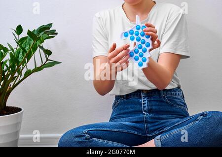 Close-up Mädchen hält in den Händen trendy einfache Grübchen Spielzeug in Form eines Einhorns. Stockfoto