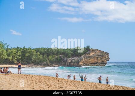 Blick auf den Shipwreck Beach, während Touristen den pazifik in Poipu genießen. Stockfoto