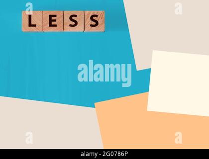 Weniger Wort auf hölzernen kubischen Blöcken mit Buchstaben. Kosten sparen Geschäftskonzept Stockfoto
