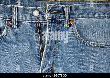 Nahaufnahme einer Jeans in Denim-Blau mit ungezippten Reißverschlüssen Stockfoto