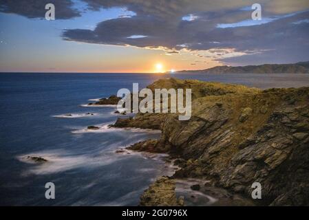 Cap Ras Küstenlandschaft, nachts, mit aufsteigendem Mond am Horizont (Costa Brava, Girona, Katalonien, Spanien) Stockfoto