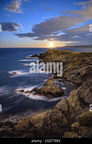 Cap Ras Küstenlandschaft, nachts, mit aufsteigendem Mond am Horizont (Costa Brava, Girona, Katalonien, Spanien) Stockfoto