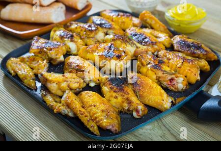 Hähnchenflügel auf Frypan mit Sauce Stockfoto