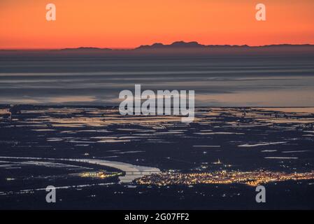Sonnenaufgang vom Mont Caro mit Blick auf das Ebro-Delta und die Serra de Tramuntana am Horizont, auf Mallorca (Naturpark Els Ports, Tarragona, Spanien) Stockfoto