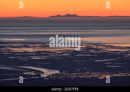 Sonnenaufgang vom Mont Caro mit Blick auf das Ebro-Delta und die Serra de Tramuntana am Horizont, auf Mallorca (Naturpark Els Ports, Tarragona, Spanien) Stockfoto