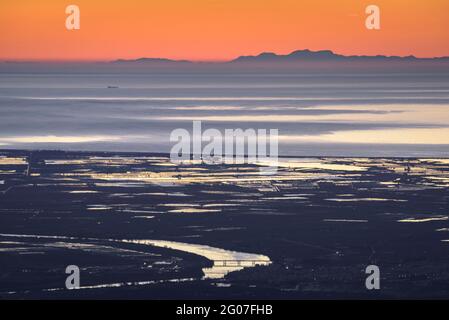 Sonnenaufgang vom Mont Caro mit Blick auf das Ebro-Delta und die Serra de Tramuntana am Horizont, auf Mallorca (Naturpark Els Ports, Tarragona, Spanien) Stockfoto