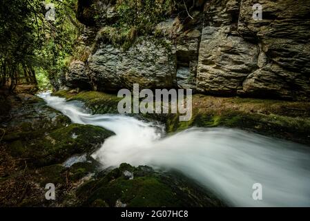 Wasserrutsche zwischen Felsen in der Quelle Bullidor de la Llet (Berguedà, Katalonien, Spanien, Pyrenäen) Stockfoto