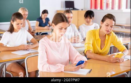 Die Schüler benutzen Smartphones während des Unterrichts Stockfoto