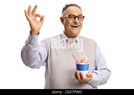 Reifer Mann hält Eis in einem Papierbecher und gestikiert ok Zeichen isoliert auf weißem Hintergrund Stockfoto