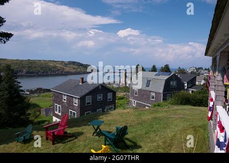 Klassische Häuser aus Zedernholz mit Blick auf die Hafenbucht. Auf der Monhegan Insel in Maine. Stockfoto