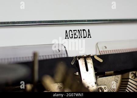 Business- und Agenda-Symbol. Das Konzeptwort 'Agenda' wurde auf der Retro-Schreibmaschine geschrieben. Schöner weißer Hintergrund. Geschäfts- und Agendakonzept. Stockfoto