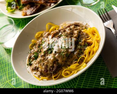 Schweineribs mit Pilzsauce und Linguine Stockfoto