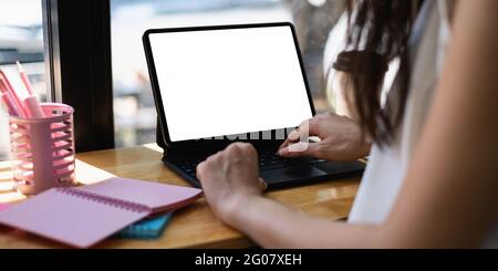 Nachbildung einer schwarzen Tafel mit weißem leeren Bildschirm auf einem Holzschreibtisch. Stockfoto
