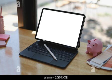 Nachbildung einer schwarzen Tafel mit weißem leeren Bildschirm auf einem Holzschreibtisch. Stockfoto