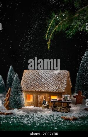 Dekorieren eines kleinen Hauses aus Keksen mit Weihnachtsdekorationen Stockfoto