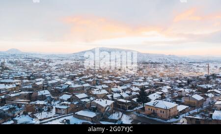 Von oben Luftaufnahme der verschneiten Stadt mit alten Verwitterte Hausgebäude gegen den trüben, trüben Himmel im Winter Türkei Stockfoto