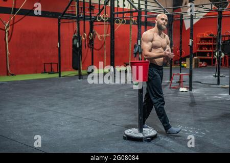 Nachdenkliche afroamerikanische Frau mit afroamerikanischen Zöpfen, die sich am Pool lehnen und das Wochenende im Spa-Center genießen, während sie die Kamera anschaut Stockfoto