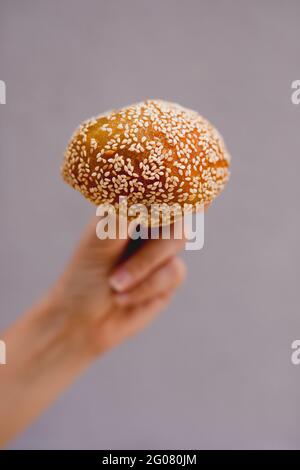 Hand einer Frau mit einem klebrigen Reiskuchen-Brötchen Stockfoto