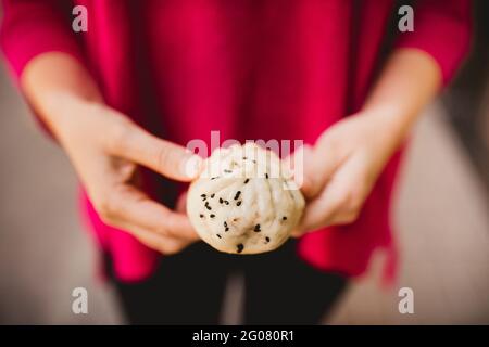 Nicht erkennbare Frau, die während der Kamera die leckere Sheng Jian Bao zeigt Auf der Straße stehen Stockfoto