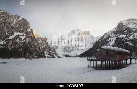 Kleines Haus im Tal zwischen majestätischen verschneiten Bergen im Winter in den Dolomiten, Italien Stockfoto