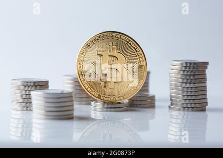 Goldene und glänzende Bitcoin-Münzen auf verschiedenen Weltwährungen, die eine Auswahl an verschiedenen Zahlungs- und Anlageoptionen darstellen. Stockfoto