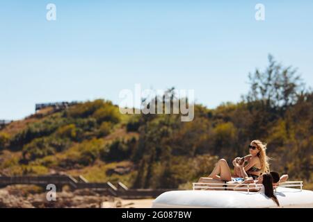 Junge Reisende genießen sonnige Tage auf dem Retro-Bus Stockfoto