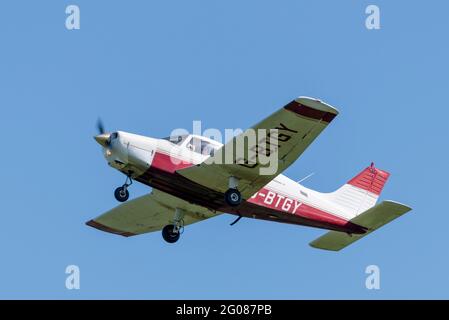 Piper PA-28 Cherokee Warrior II Leichtflugzeug, das am blauen Himmel auf dem Stapleford Aerodrome, Essex, Großbritannien, fliegt. Pilotenausbildung durch Stapleford Flying Club Stockfoto