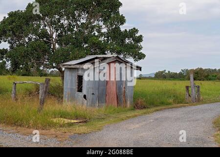 Eine verfallene alte Blechhütte an der Seite einer Zufahrtsstraße zu einem privaten Landgut Stockfoto