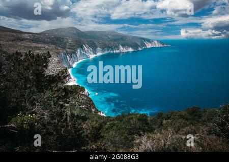 Fteri Beach. Blaue Lagune mit felsiger Küste, Kefalonia, Griechenland. Ruhiges klares blaues smaragdgrün türkisfarbenes Meerwasser mit dunkeltiefem Muster. Stockfoto