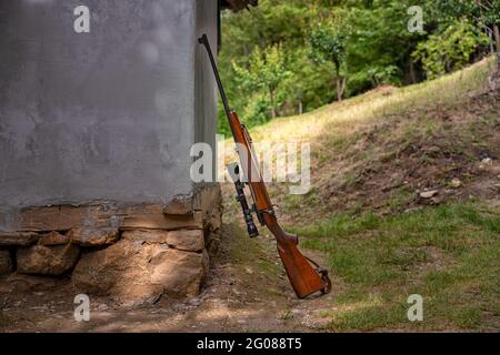 Karabiner lehnte sich an ein altes Haus auf dem Land Stockfoto