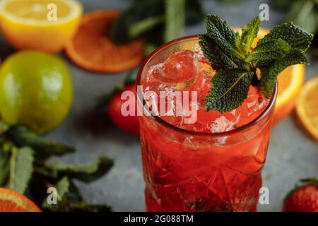 Bunte Erfrischungsgetränke für den Sommer, kalter Erdbeer-Limonensaft mit Eiswürfeln in den Gläsern garniert mit frisch geschnittenen Zitronen Stockfoto