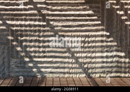 Textur Hintergrund der welligen Gebäudefliese mit Sonnenlicht Stockfoto