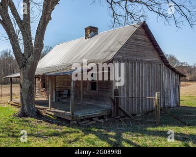 Alte verlassene Pioneer Holzhütte mit einer überdachten Veranda, im ländlichen Alabama, USA. Stockfoto