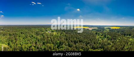 Idyllisches Wohnen zwischen einem grünen, frisch gelüfteten Wald in Panoramalage an einem sonnigen Tag im Frühling, bayern deutschland. Stockfoto