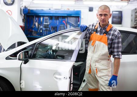 Professioneller Automechaniker posiert in der Werkstatt Stockfoto