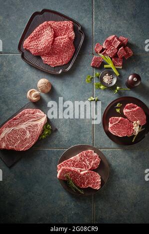 Draufsicht auf rohe Rindersteaks auf grauem Hintergrund Stockfoto