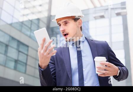 Porträt eines besorgten Ingenieurs, der am Touchpad arbeitet Stockfoto