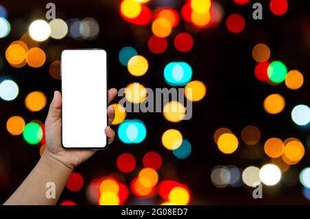 Hand halten Telefon Mockup Bild leeren Bildschirm für Werbung Text in Bokeh Hintergrund. Stockfoto