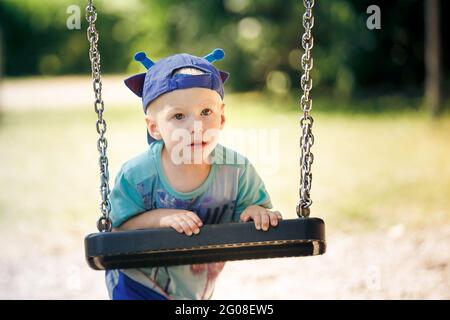 Porträt eines kleinen Jungen, der im Park mit Schaukel spielt Stockfoto