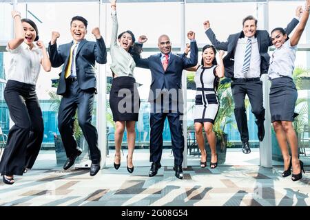 Diversity Business Team Jumping feiert Erfolge, chinesische, indonesische, indische und kaukasische Ethnien Stockfoto