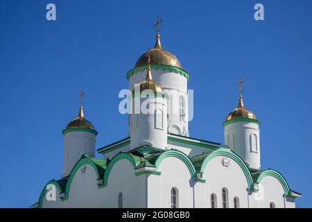 Östliche orthodoxe Kreuze auf goldenen Kuppeln gegen den blauen Himmel. Stockfoto