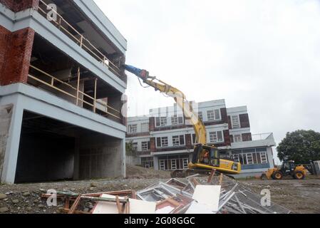 GREYMOUTH, NEUSEELAND, 19. Januar 2021: Ein Bagger nutzt einen Klauenaufsatz, um das alte Krankenhausgebäude in Greymouth, Neuseeland, im Januar abzureißen Stockfoto