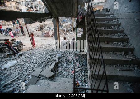 Gaza, Palästina. Juni 2021. Eine palästinensische Familie sitzt vor der Tür ihres zerstörten Hauses. Die Nachwirkungen der 11-tägigen Feindseligkeiten zwischen Israel und Gaza-Führung Hamas. Kredit: SOPA Images Limited/Alamy Live Nachrichten Stockfoto