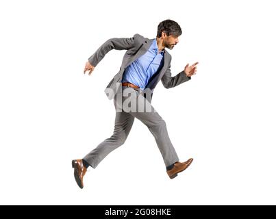 Ein Geschäftsmann in einem eleganten Anzug, der sehr schnell in Eile läuft und einen zielstrebig fokussierten Ausdruck auf einem weißen Hintergrund ausdrückt Stockfoto