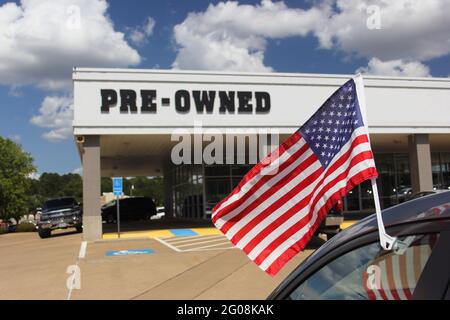 Gebrauchtwagenhändler mit American Flag Shallow DOF, Fokus auf Fahnenmast Stockfoto