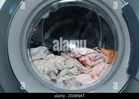 Frontlader-Waschmaschine mit nasser Kleidung und Handtuch darin Stockfoto