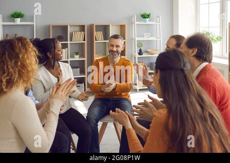 Glückliche Patienten applaudieren reifen Psychologen oder Therapeuten nach Gruppentherapie Sitzung Stockfoto