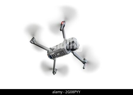 Ein fliegender Quadcopter ist auf blauem Hintergrund isoliert. Stockfoto